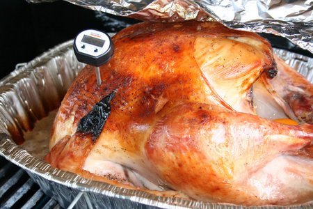 Whole turkey roasting on a grillの写真素材