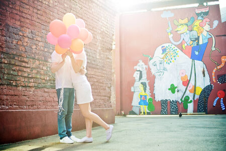 Loving couple kissing spratavshis for balloons  Moscow  May 22, 2012のeditorial素材