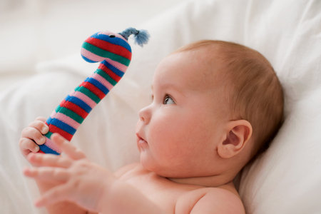 baby lying down holding a stuffed toy