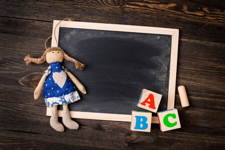 chalkboard and ABC letters on a wooden background with a dollの写真素材