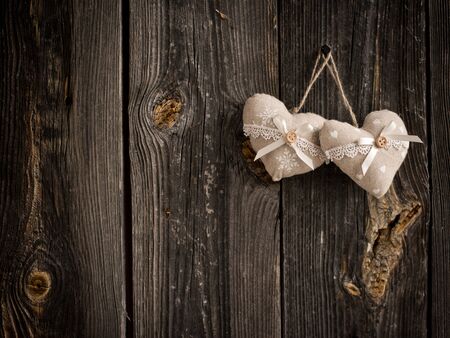 wooden heart hanging on a branch against white wooden planksの写真素材