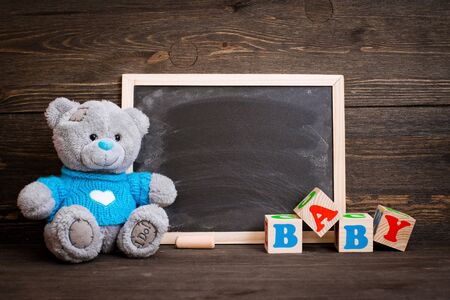 chalk board and a teddy bear on a wooden backgroundの写真素材