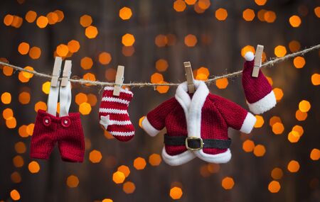 santa clothing on a clothesline on a background of lightsの写真素材