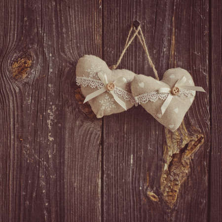 wooden heart hanging on a branch against white wooden planksの写真素材