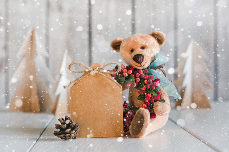 Teddy Bear with a blank for congratulations on a wooden backgroundの写真素材