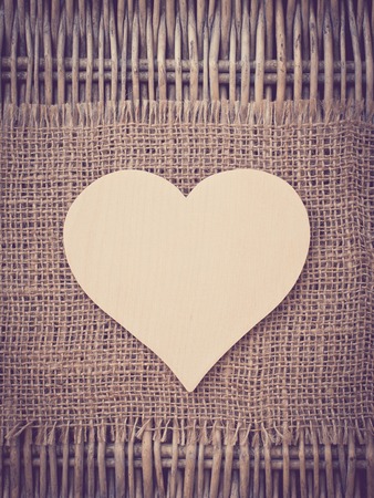 Blank wooden heart on fabric background tonedの写真素材