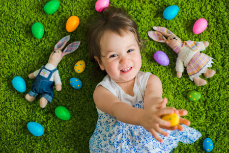 child lies on the grass with Easter eggs and a hare