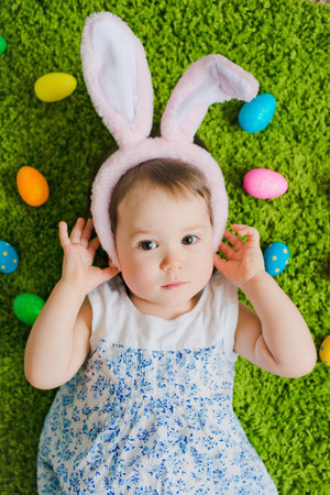 child lies on the grass with Easter eggs and a hare