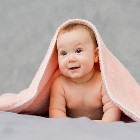 The baby looks under the towelの写真素材