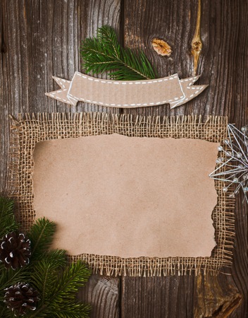 Christmas letter, list, congratulations on a wooden background. free space, mockup new Year. Spruce branches and decoration with their own hands. Cheap greetingsの写真素材