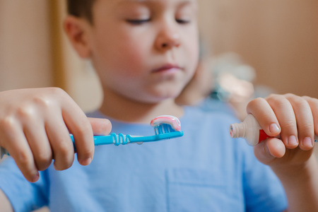 Happy kid or child brushing teeth in bathroom. Dental hygiene.の写真素材