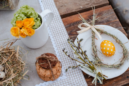 Decorative nest of straw on a plate with Easter quail egg on a served festive table in the garden...