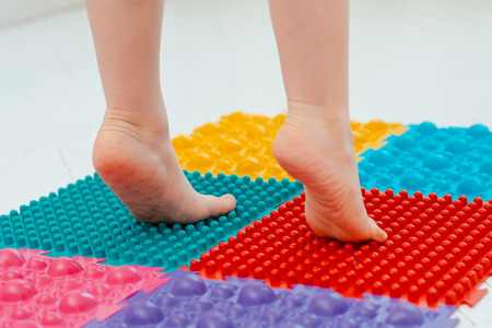 Toddler baby foot massage mat. Exercises for legs orthopedic massage carpet. prevention flat feet and hallux valgus Orthopedic massage puzzle floor mats for development children.の写真素材