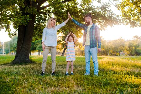 Happy young family spending time together outside in green nature. Parents, childhood, child, care, daughter, father, motherの写真素材
