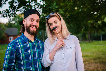 Funny man, woman with protruding tongues in rocker style scream. Family of fun hipsters fooling...