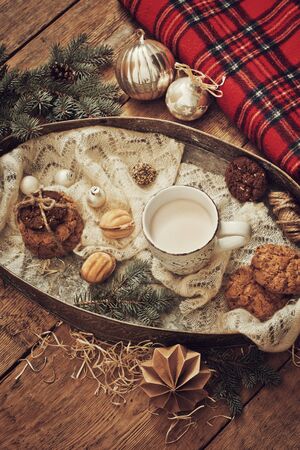 Mug with drink and cookies with Christmas decoration on wooden backgroundの写真素材