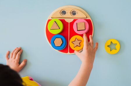 little girl collects wooden multi-colored sorter Safe natural wooden kids toys Educational gameの写真素材