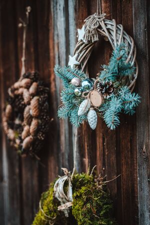 festive rustic wreaths of cones and moss on a dark brown wooden background. Christmas and New year holiday concept. House decoration. free space for text.の写真素材