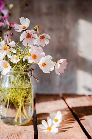 Beautiful bouquets of wildflowers on a wooden table on a cold concrete wall background. Simple floral arrangements made by a florist in a rustic style. free spaceの写真素材