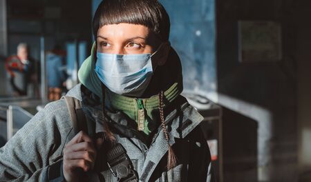 A man in a medical protective mask on public transport. Concept of human use of protective face masks against viral infection in the context of the coronavirus crisis in 2020, cavid-19, quarantineの写真素材