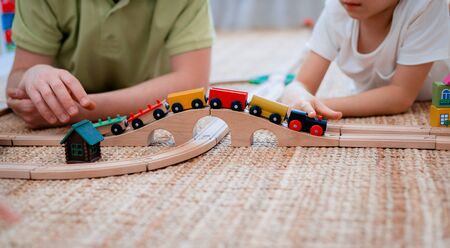 family father and son play a toy wooden railway in the game room. The concept of a parent and child spending time together.の写真素材
