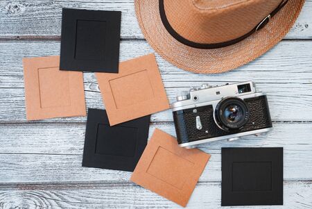 Lay flat white wooden background, vintage summer accessories, vintage film camera, save memories of summer. pictures in framesの写真素材