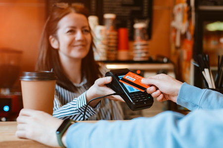 barista submits a terminal for non-cash payment. Customer paying bill through card using NFC...