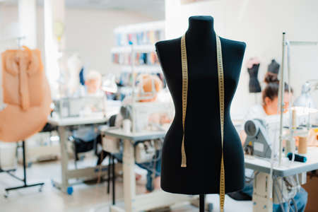 Fashion creative design studio interior concept with mannequin dummy and stylish fashionable trendy clothes on hangers, dressmaking workplace, tailor shop, sewing workshopの写真素材
