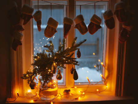 Christmas rustic old window at night with decorated spruce branches in a glass jar retro decorationsの写真素材
