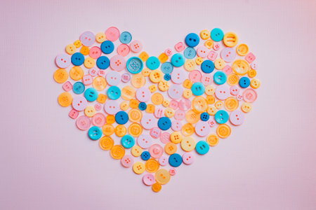 multi colored buttons heart shape paper background. Template for card, invitation. Blank space for...
