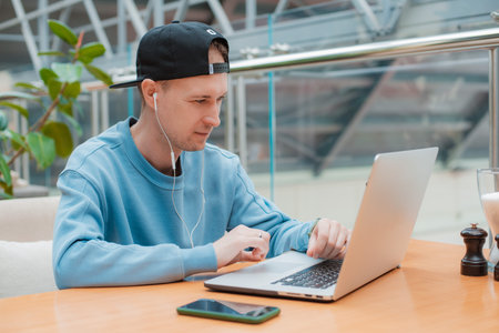 Young guy male businessman thinking about online project, looking laptop work cafe, thinking...