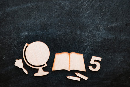 Wooden mock-up of school supplies and drawings on the blackboard, lying in an even layer. Space for text, Globe, notebook, grades, pencilsの写真素材