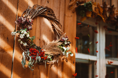 Decorative design window on the terrace. autumn wreath and pumpkins vintage old chest of drawers on wooden rustic background. autumn composition and recreation area sun rayの写真素材
