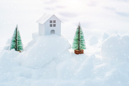 Decorative white house with a spruce tree in the snow in the sunlight outdoors, free space,...