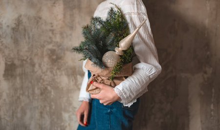 Woman holding hands small Christmas tree decorated with glass file craft paper concrete background. Festive background free space for greeting text.の写真素材