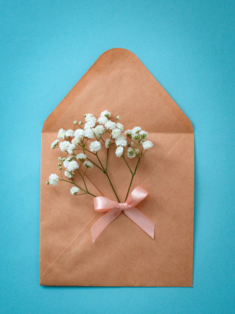 craft envelope with a bouquet of flowers with pink hearts on a blue background. mail concept....