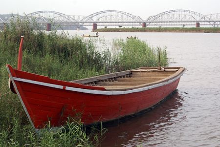 Red boat on the river and bridge        の写真素材