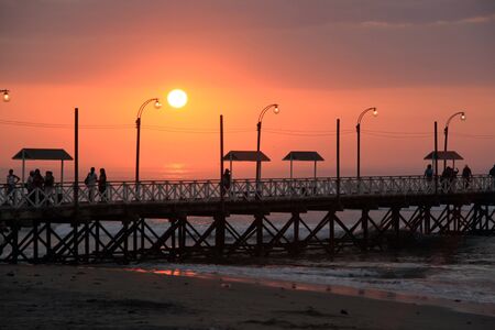 Sunset and pier on the sea coast in north Peruの写真素材