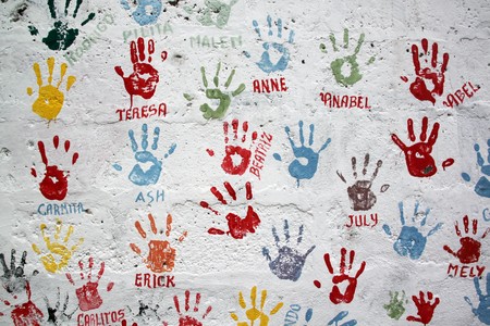 Color child palms on the white wall on the streetの写真素材