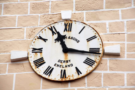 Old iron inglish clock on the ston wall