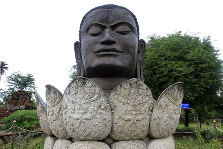 Big bronze head of Buddha and lotuses in Wat Thummikaratのeditorial素材