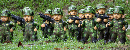 Soldiers doll in green uniform on the gras ander tree