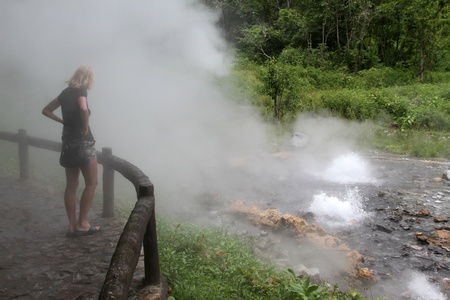 Woman looking on the Pongduet geyser, Northern Thailandの写真素材
