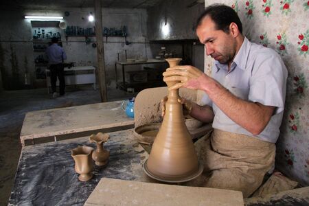 LALEJIN, IRAN - CIRCA APRIL 2013 iranian worker with ceramic vaseのeditorial素材
