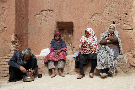 ABYANEH, IRAN 0 CIRCA APRIL 2013 Man and women near wall のeditorial素材
