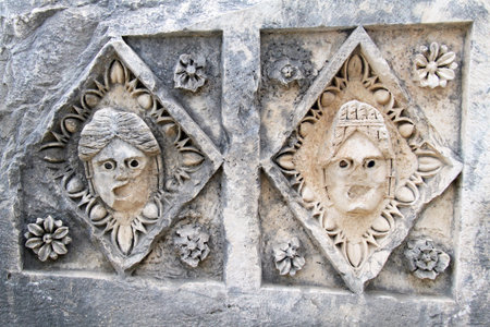 Two theater masks on the stone in Myra, Turkeyの写真素材