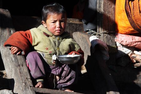 SAMAGOON, NEPAL - CIRCA OCTOBER 2013 Young boy with plate with riceのeditorial素材