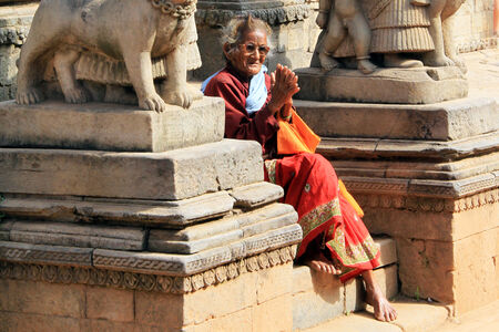 BHAKTAPUR, NEPAL - CIRCA NOVEMBER 2013 Old woman on the steps of templeのeditorial素材