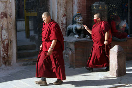 KATHMANDU, NEPAL - CIRCA NOVEMBER 2013 Two monks walk near stupa Bodnathのeditorial素材