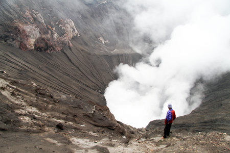 Man standing inside crater of volcano Bromo in Indonesiaの写真素材